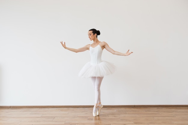 Bella ballerina che si piega senza sforzo sul palco con armonia