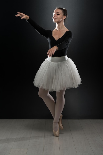 Bella ballerina femminile su sfondo nero Ballerina indossa un tutù e scarpe da punta