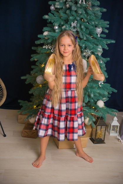 bella bambina che celebra il natale a casa in abito