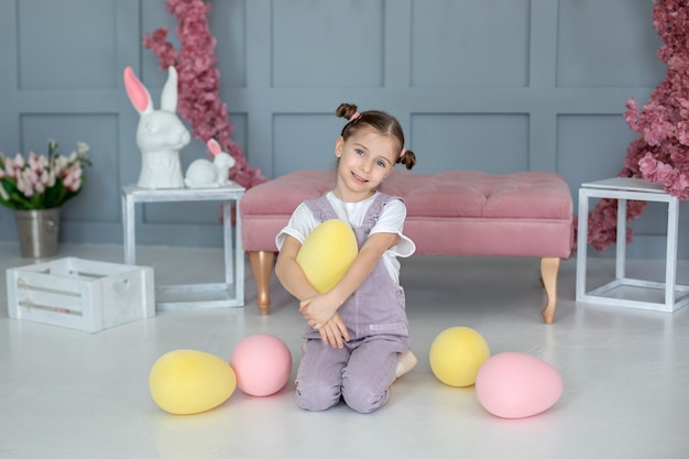 bella bambina che gioca con uova giocattolo colorate che raccolgono le uova di Pasqua del piccolo contadino