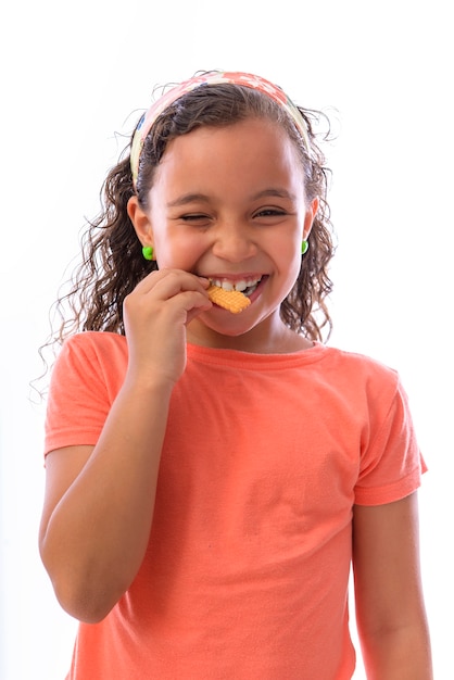 Bella bambina che mangia un biscotto