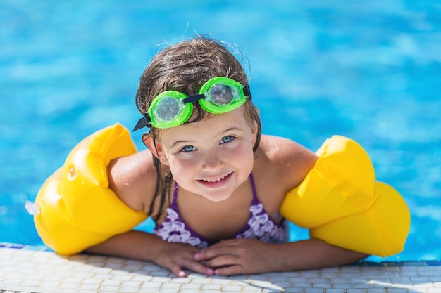 Bella bambina che prende il sole in piscina