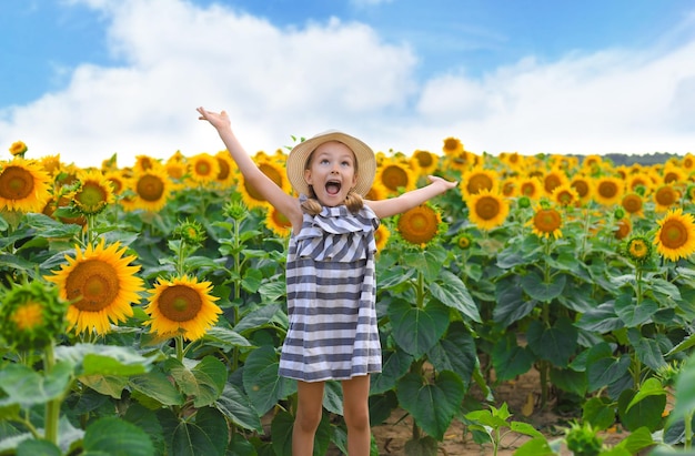 Bella bambina che si gode la natura Bambino femmina sorridente felice in piedi nel campo di girasoli