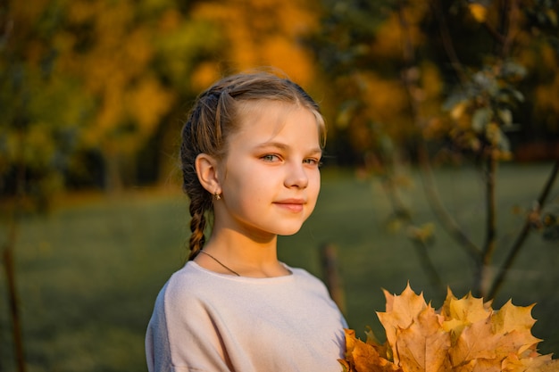 Bella bambina con foglie d'autunno