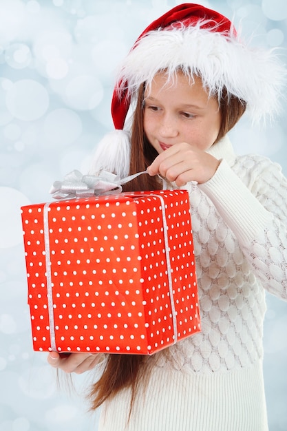 Bella bambina con scatola regalo su sfondo luminoso