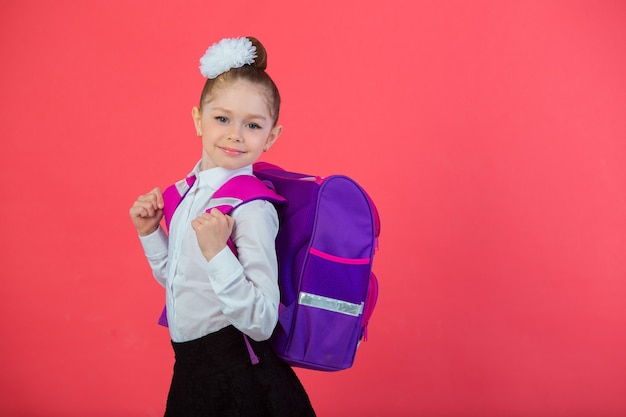 bella bambina con un fiocco con una cartella di scuola