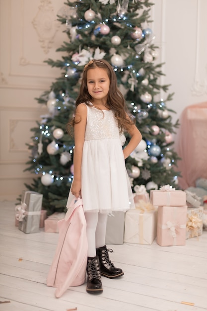 Bella bambina in posa vicino all'albero di Natale.