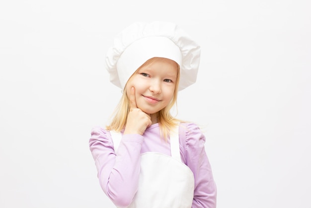 Bella bambina in uniforme da chef isolata on white