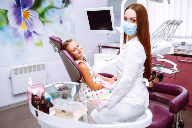 Bella bambina sorridente dopo aver fatto l'esame in una stomatologia pediatrica Cura dei denti da latte