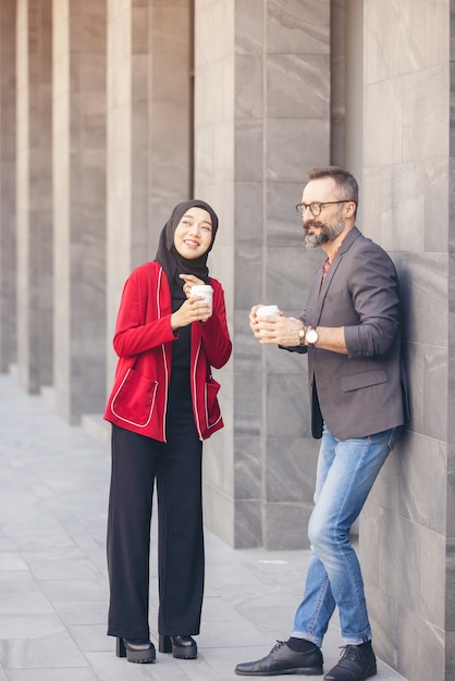Bella barba uomo d'affari di mezza età bere caffè all'aperto caffè caffè con giovane bella donna musulmana