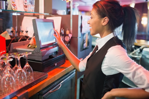 Bella barista che usa il touchscreen