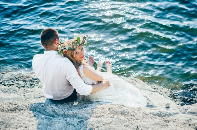 bella bellissima bionda sposa e lo sposo elegante, sullo sfondo di un mare