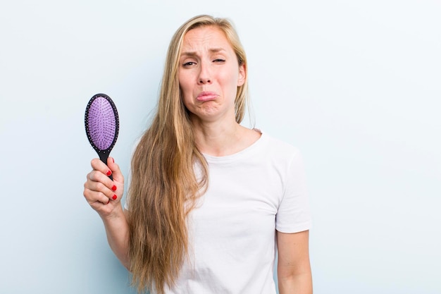 Bella bionda giovane donna adulta con un pettine per capelli