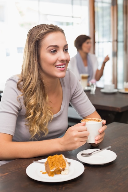 Bella bionda godendo torta e caffè