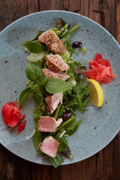 Bella bistecca di tonno al sesamo lime e insalata fresca primo piano su un piatto sul tavolo