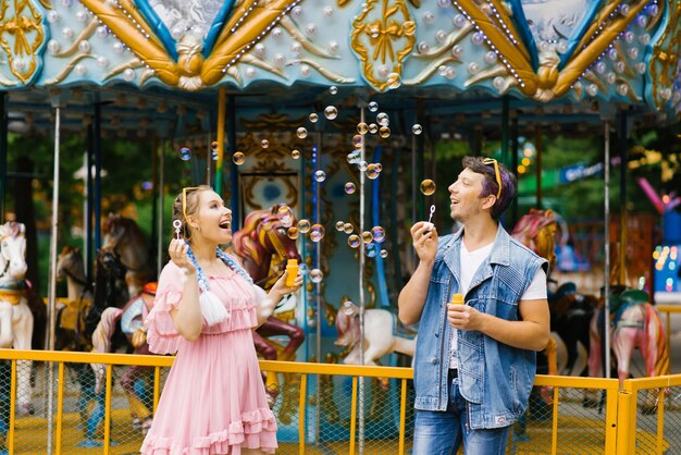 bella brillante allegra romantica coppia innamorata godere bolle di sapone in un parco di divertimenti