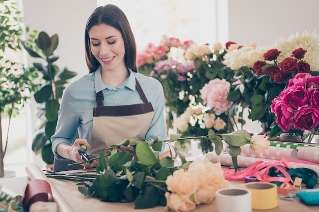 bella bruna botanica in posa nel suo negozio di fiori