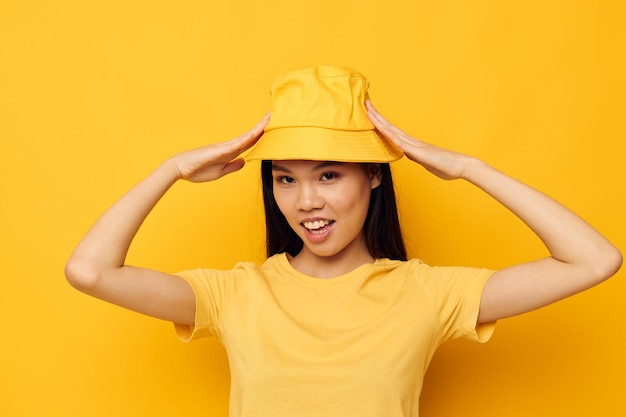 Bella bruna che indossa un cappello giallo in posa di emozioni modello in studio inalterato