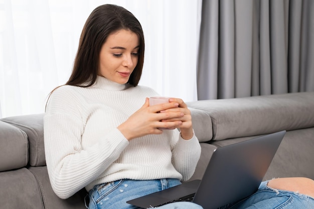 Bella bruna con i capelli lunghi che guarda video con una piacevole conversazione online utilizzando il computer