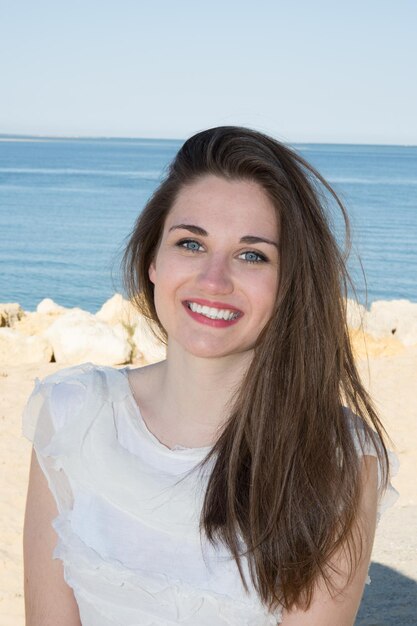 Bella bruna con i capelli lunghi sulla spiaggia Bellezza naturale della donna