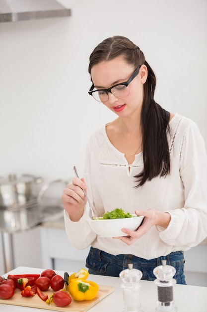 Bella bruna preparando un&#39;insalata sana