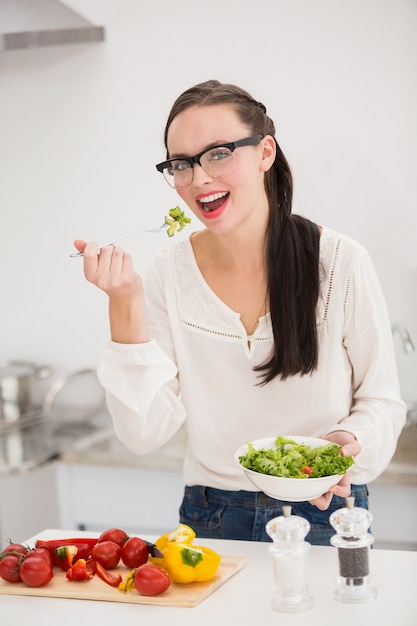 Bella bruna preparando un&#39;insalata sana