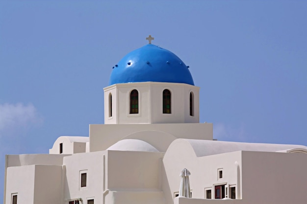 Bella casa bianca tradizionale con cupole blu nel villaggio di Oia Santorini Grecia cielo blu