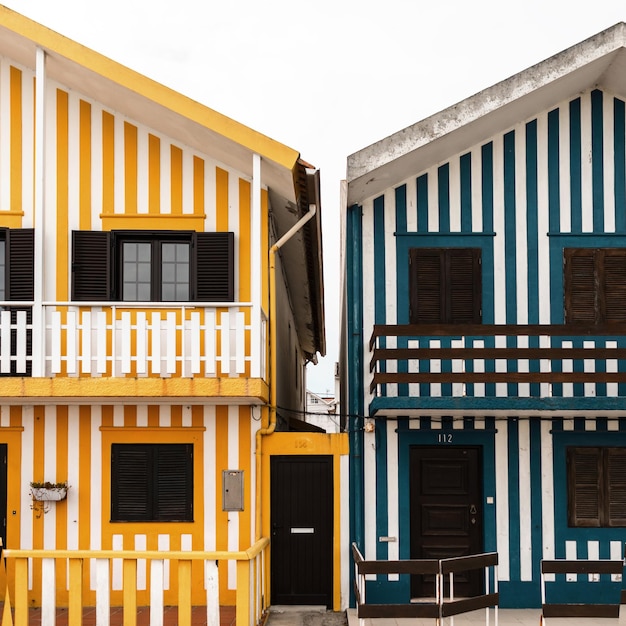 Bella casa creativa con divertenti strisce gialle e bianche con finestre, balcone e terrazza in Portogallo