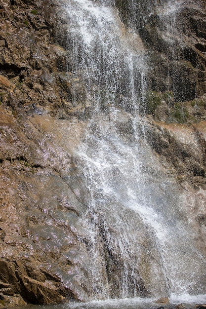 Bella cascata in montagna L'acqua scorre giù dalle montagne