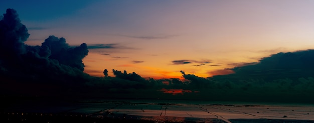 Bella Cloudscape e cielo al tramonto drammatico scuro in spiaggia