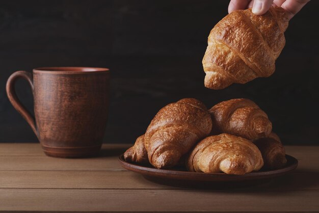 Bella colazione mattutina con croissant freschi e cappuccino al caffè Colazione gustosa e sana tavolo in legno marrone