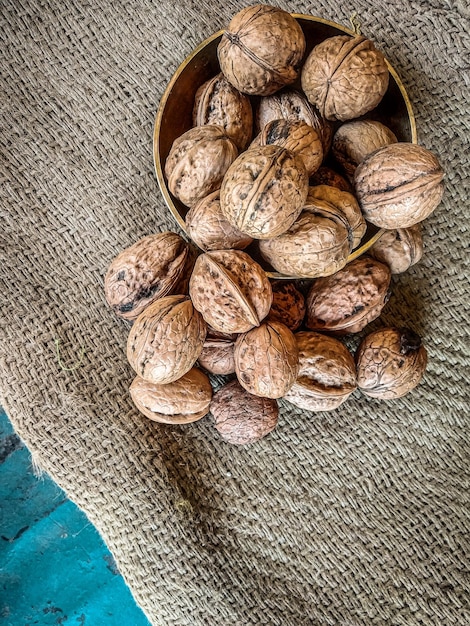 Bella composizione con noci sul sacco. Noci sulla tavola o noci sulla ciotola dorata con