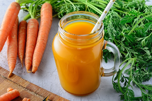 Bella composizione con un barattolo di succo di carota e verdure