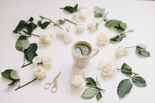 Bella composizione con una tazza di tè matcha e fiori su bianco