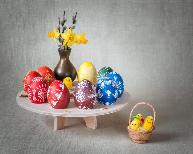 Bella composizione con uova dipinte, rami di salice e bouquet di fiori primaverili
