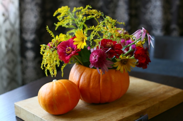 Bella composizione di fiori autunnali .. bouquet di fiori di zucca arancione e giallo mamme. Decorazione di vacanze autunnali.