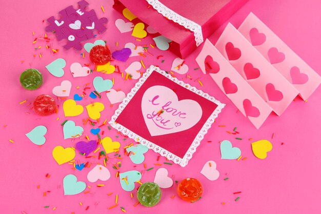 Bella composizione di San Valentino di carta e decorazioni su sfondo rosa close-up