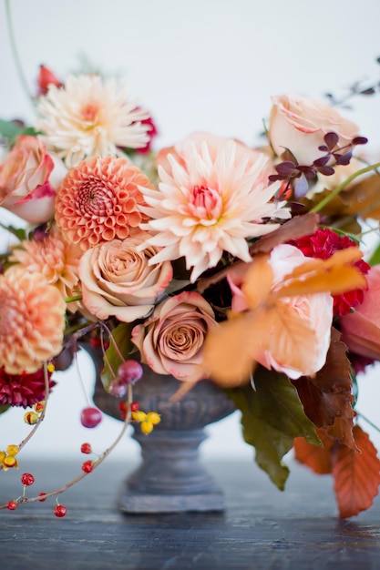 Bella composizione floreale con fiori e bacche arancioni e rossi autunnali Bouquet autunnale in vaso vintage su sfondo bianco