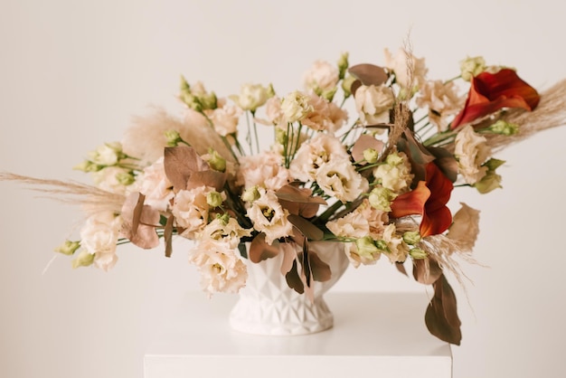 Bella composizione floreale in una pentola e un bouquet su sfondo chiaro