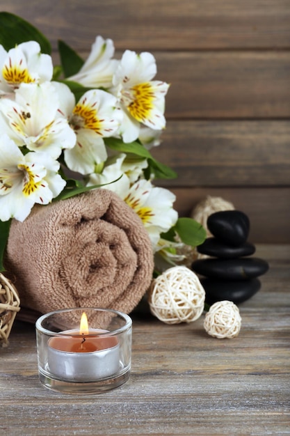 Bella composizione spa con candela e fiori su fondo in legno