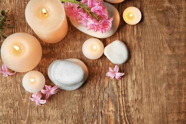 Bella composizione spa con pietre fiori e candele su sfondo di legno