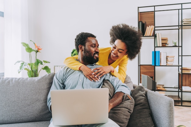 Bella coppia afro-americana che lavora su un dispositivo portatile per computer - Coppia moderna che fa shopping online