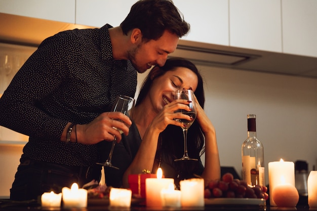 Bella coppia appassionata avente una romantica cena a lume di candela a casa, baci