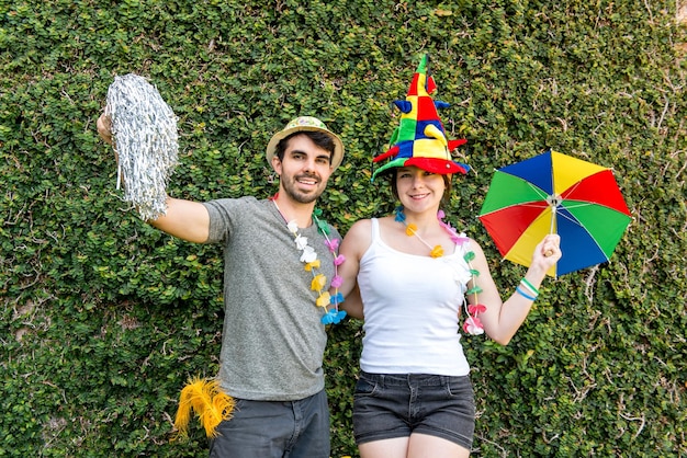 Bella coppia brasiliana che celebra una parete verde di festa di carnevale nei precedenti