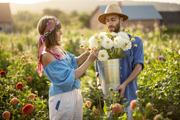 Bella coppia con fiori di dalia in giardino all'aperto