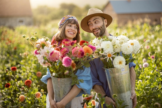 Bella coppia con fiori di dalia in giardino all'aperto