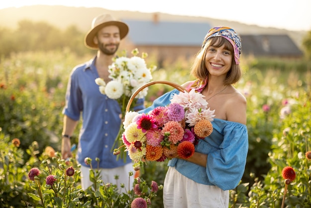 Bella coppia con fiori di dalia in giardino all'aperto