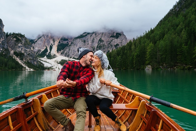 Bella coppia di giovani adulti che visitano un lago alpino a Braies Italia