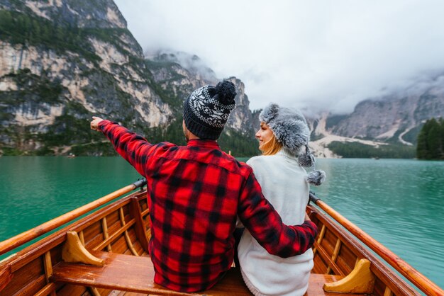 Bella coppia di giovani adulti che visitano un lago alpino a Braies Italia