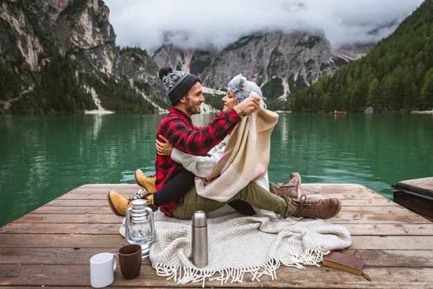 Bella coppia di giovani adulti che visitano un lago alpino a Braies Italia